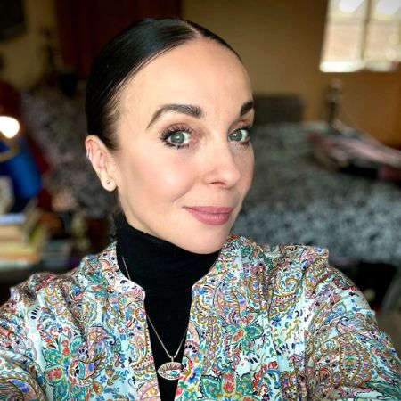 Amanda Abbington is wearing a jacket with some flowers design on it.